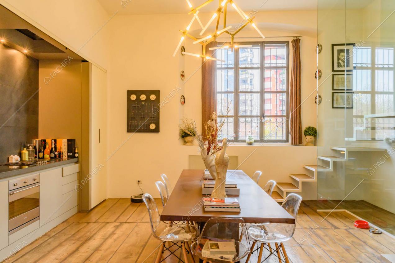 Cucina a parete con pavimento in parquet, pareti bianche e tavolo da pranzo