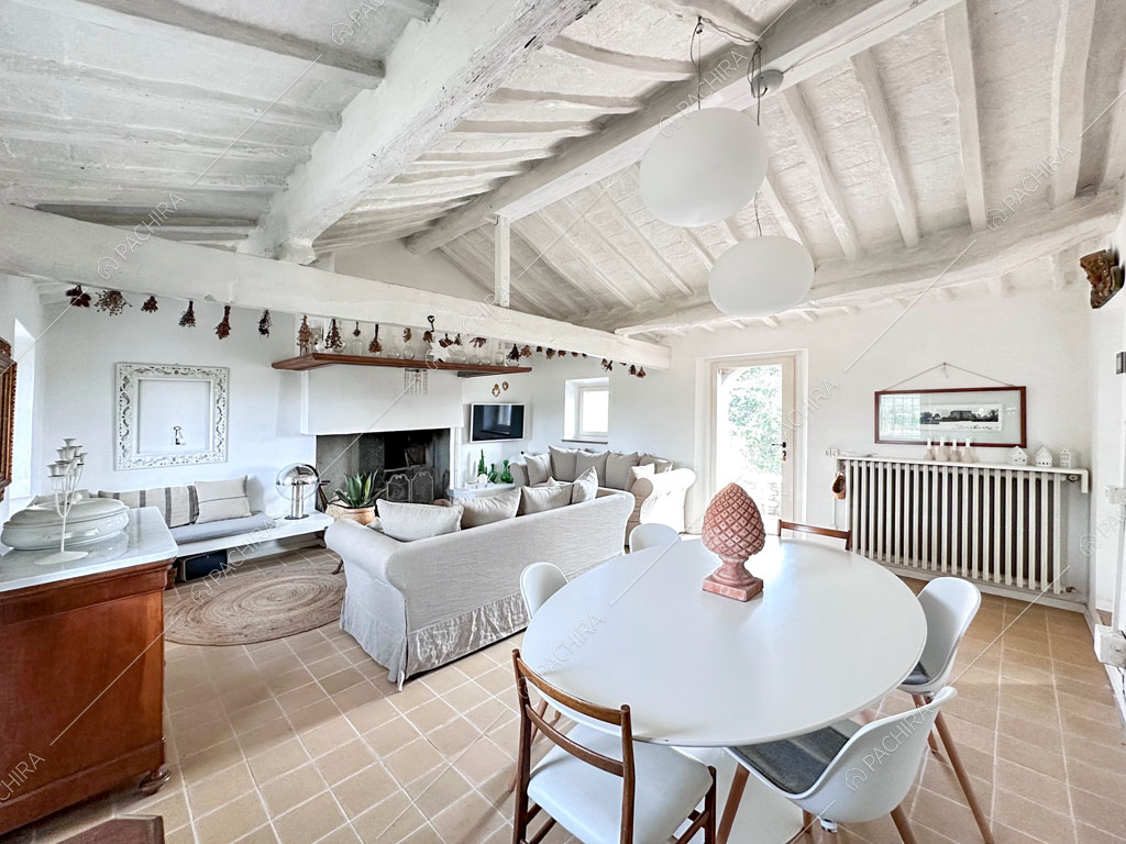 Tavolo da pranzo bianco nella zona living con camino e pavimento in piastrelle beige