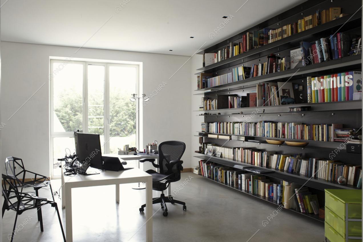 Studio con scrivania, sedie nere e grande libreria