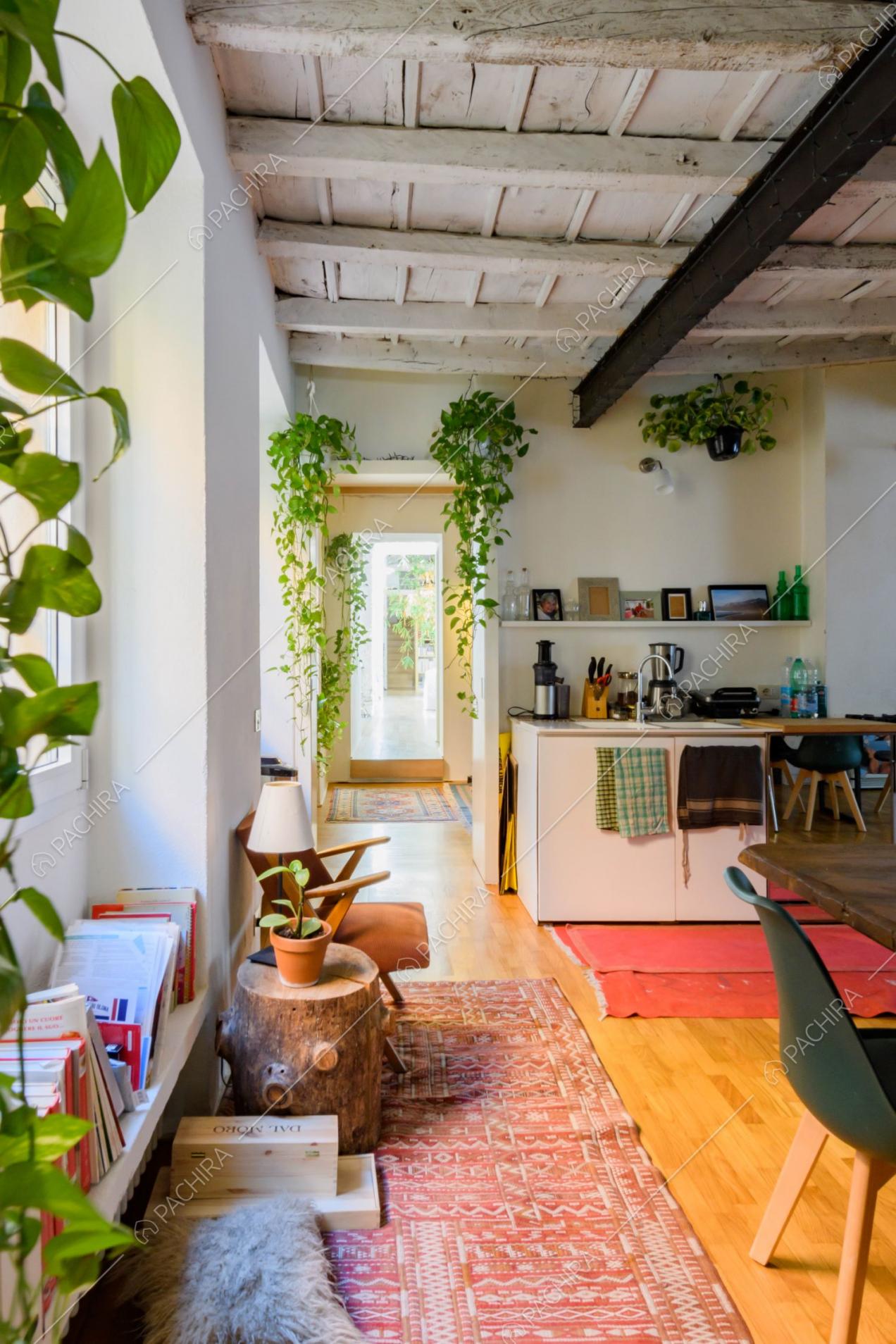 Luminosa cucina con pavimento in parquet, travi a vista e pareti bianche