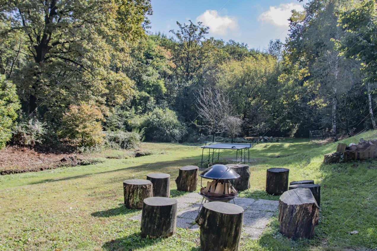 Giardino con sgabelli ricavati da tronchi e postazione per falò