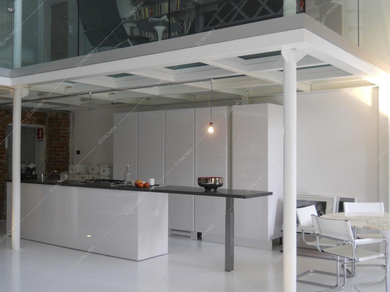 Cucina a vista bianca e soppalco con libreria