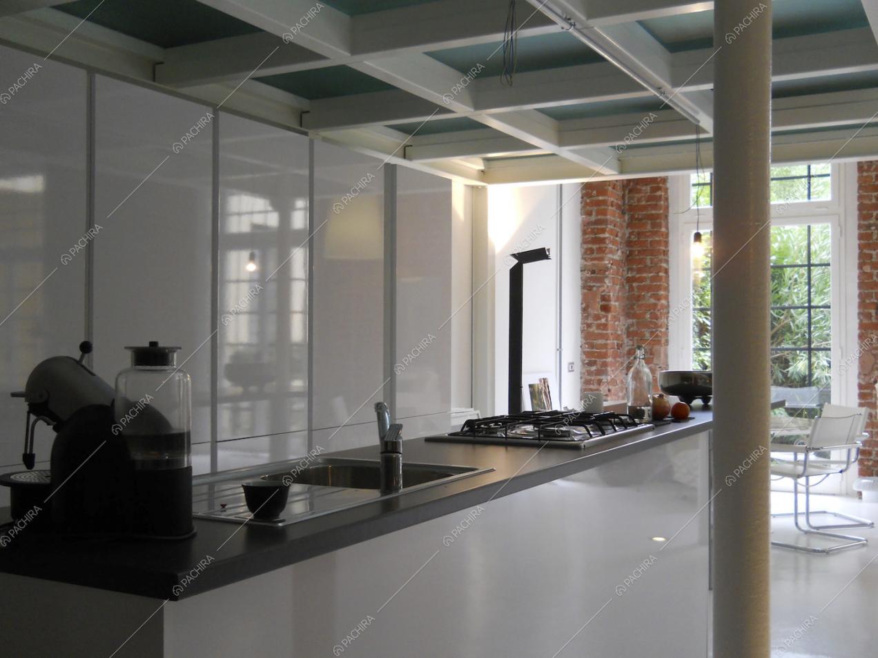 Cucina a isola con fornelli a gas illuminata dalla porta-finestra