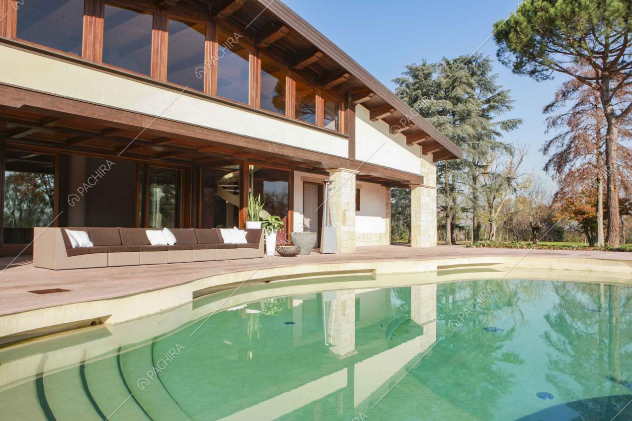 Piscina posta davanti alla veranda con divano da esterno
