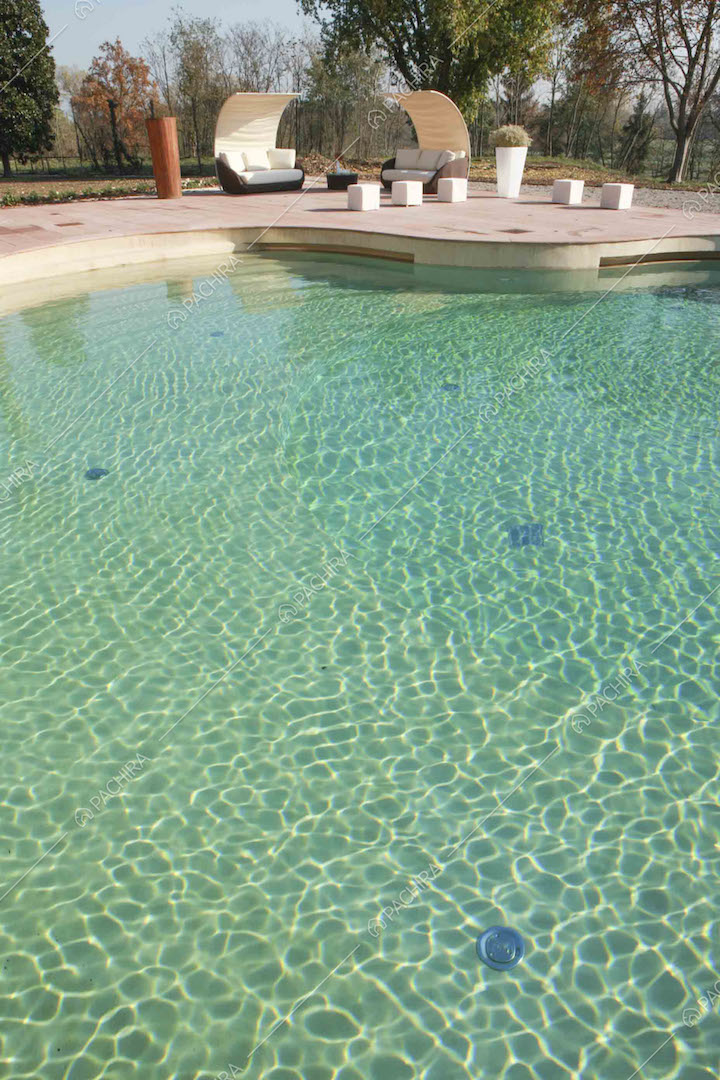 Dalla piscina vista sui divani da esterno e sul parco
