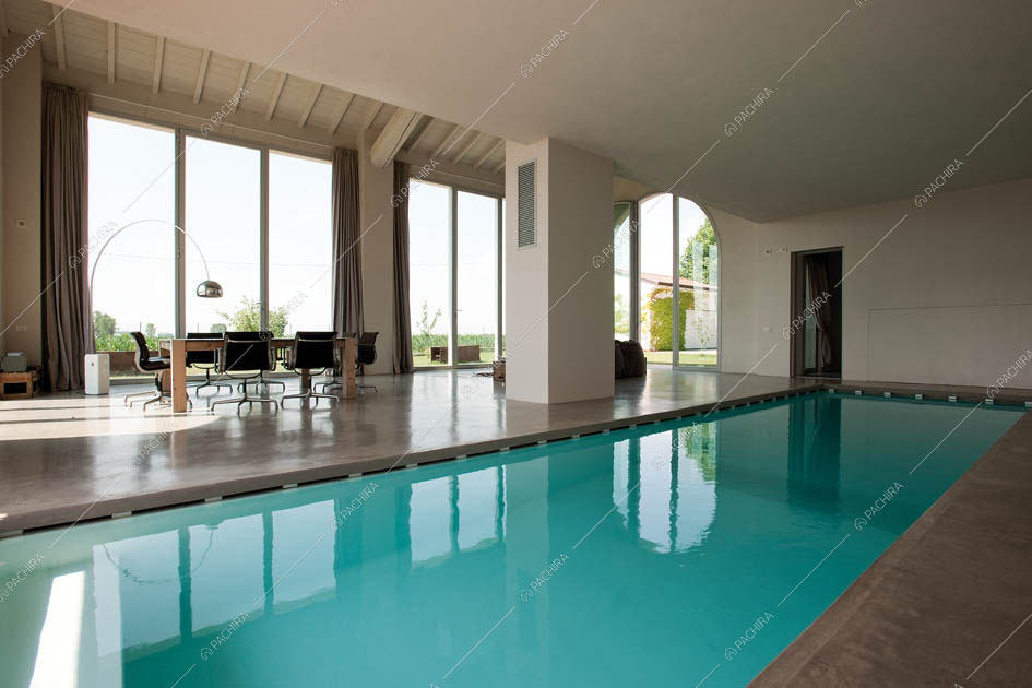 Piscina coperta, pavimento in cemento lisciato, tavolo e vetrate