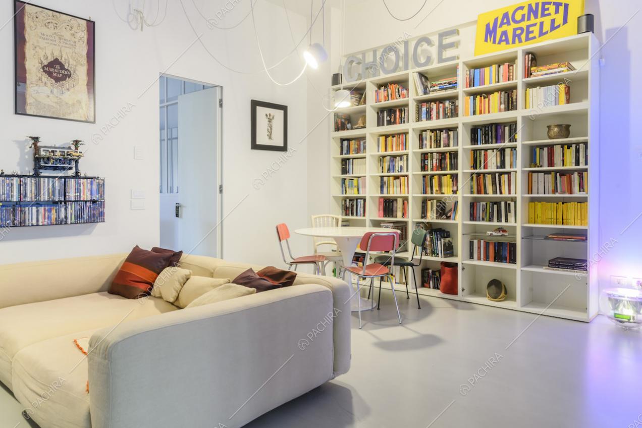 Divano e libreria bianchi in salotto dallo stile contemporaneo