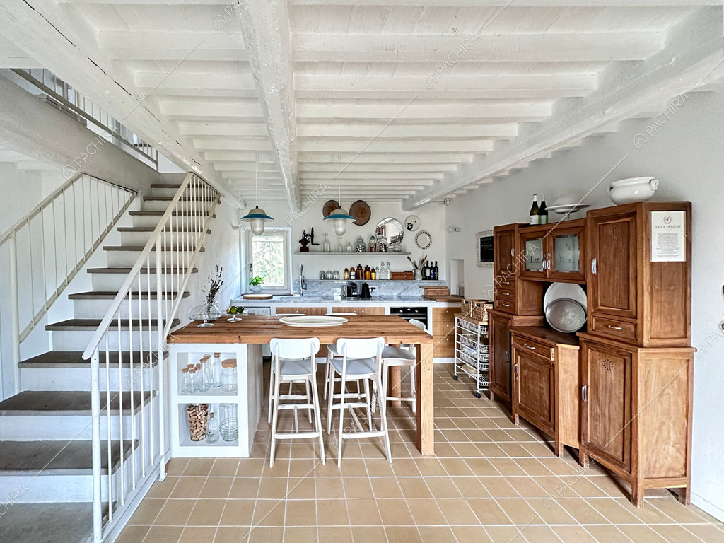 Tavolo da pranzo nella cucina a parete con fornelli a induzione e vista sulle scale