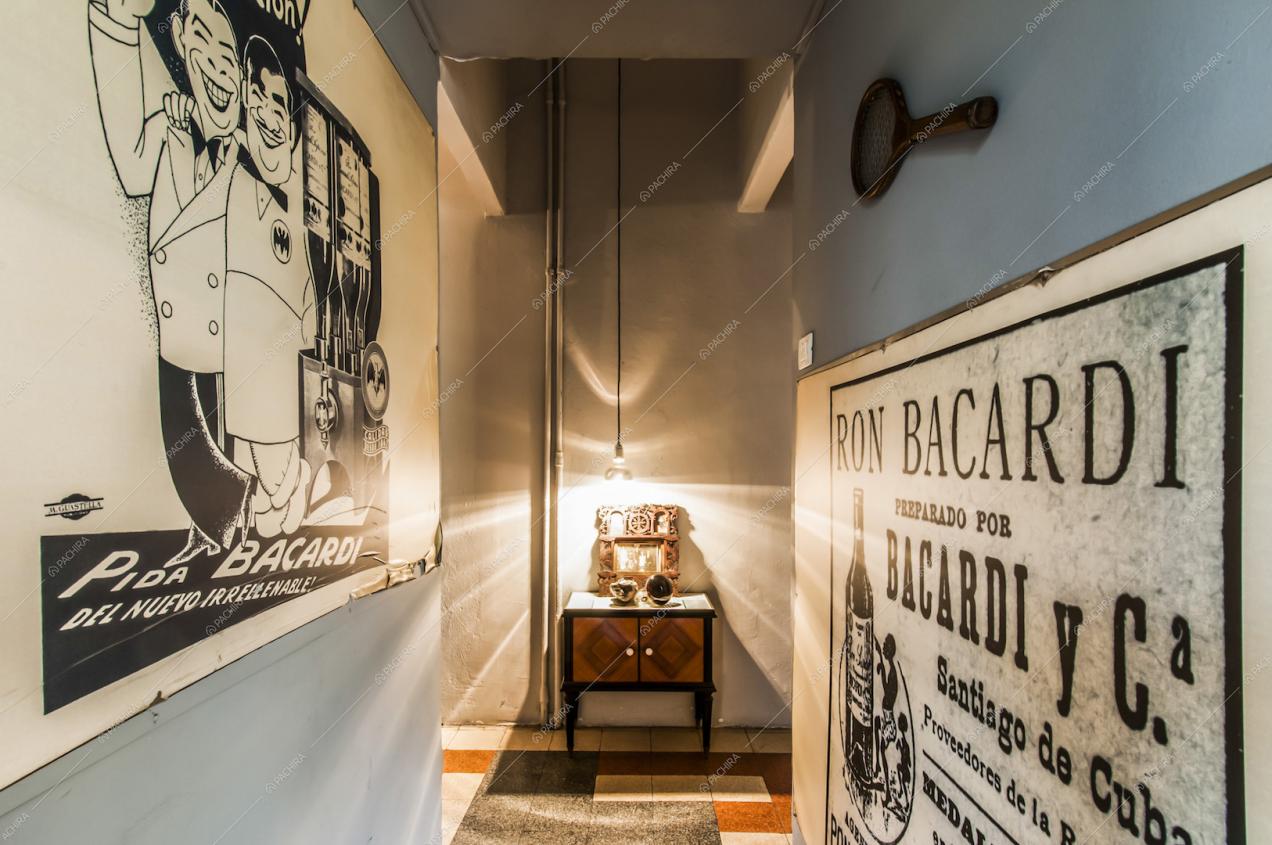 Locandine vintage e racchetta da tennis d'epoca sulle pareti del corridoio
