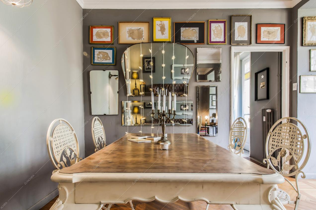 Tavolo da pranzo, parete con specchi e quadri