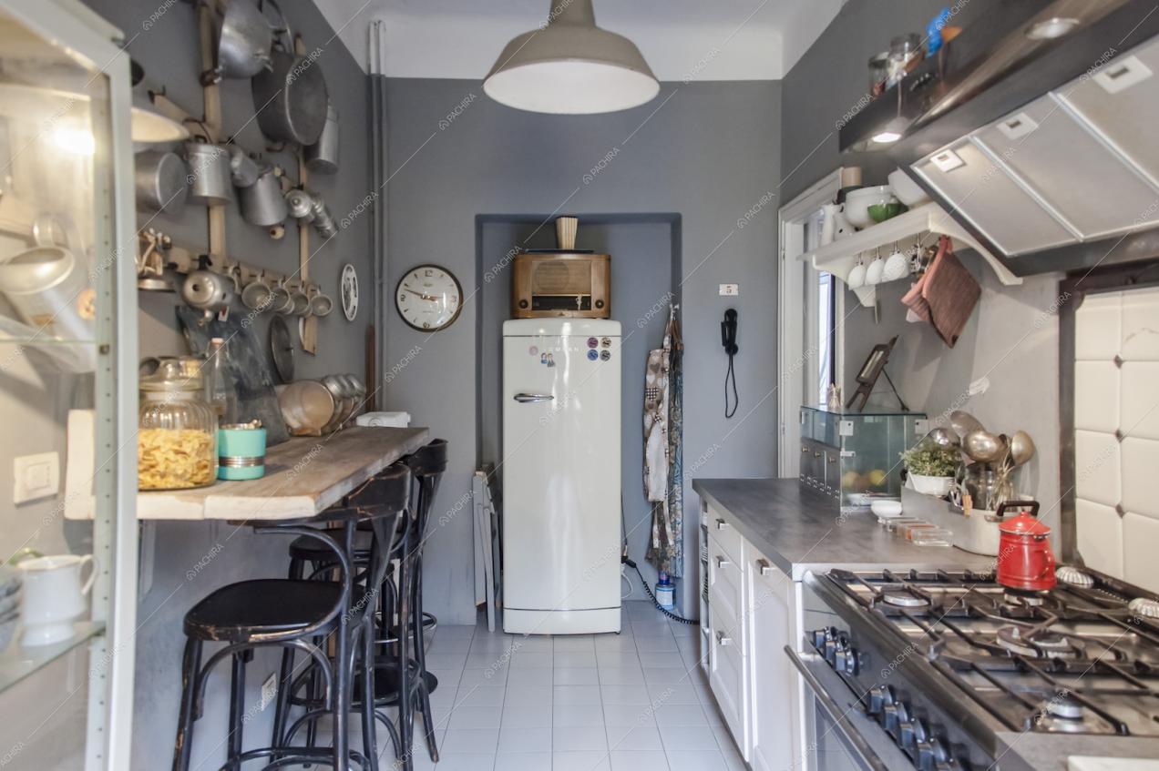 Cucina con fornelli a gas e pareti grigie