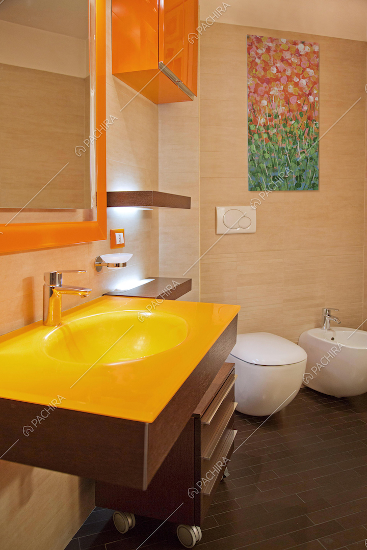 Bagno con lavandino giallo e sanitari sospesi