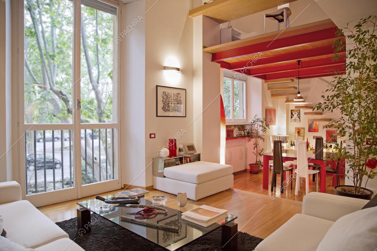 Zona living con scorcio sul soppalco e scale sospese