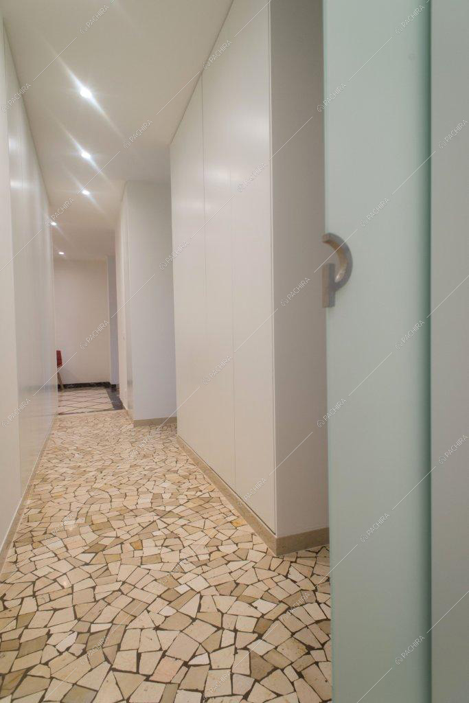 Corridoio con pavimento in marmo e pareti e soffitto bianchi
