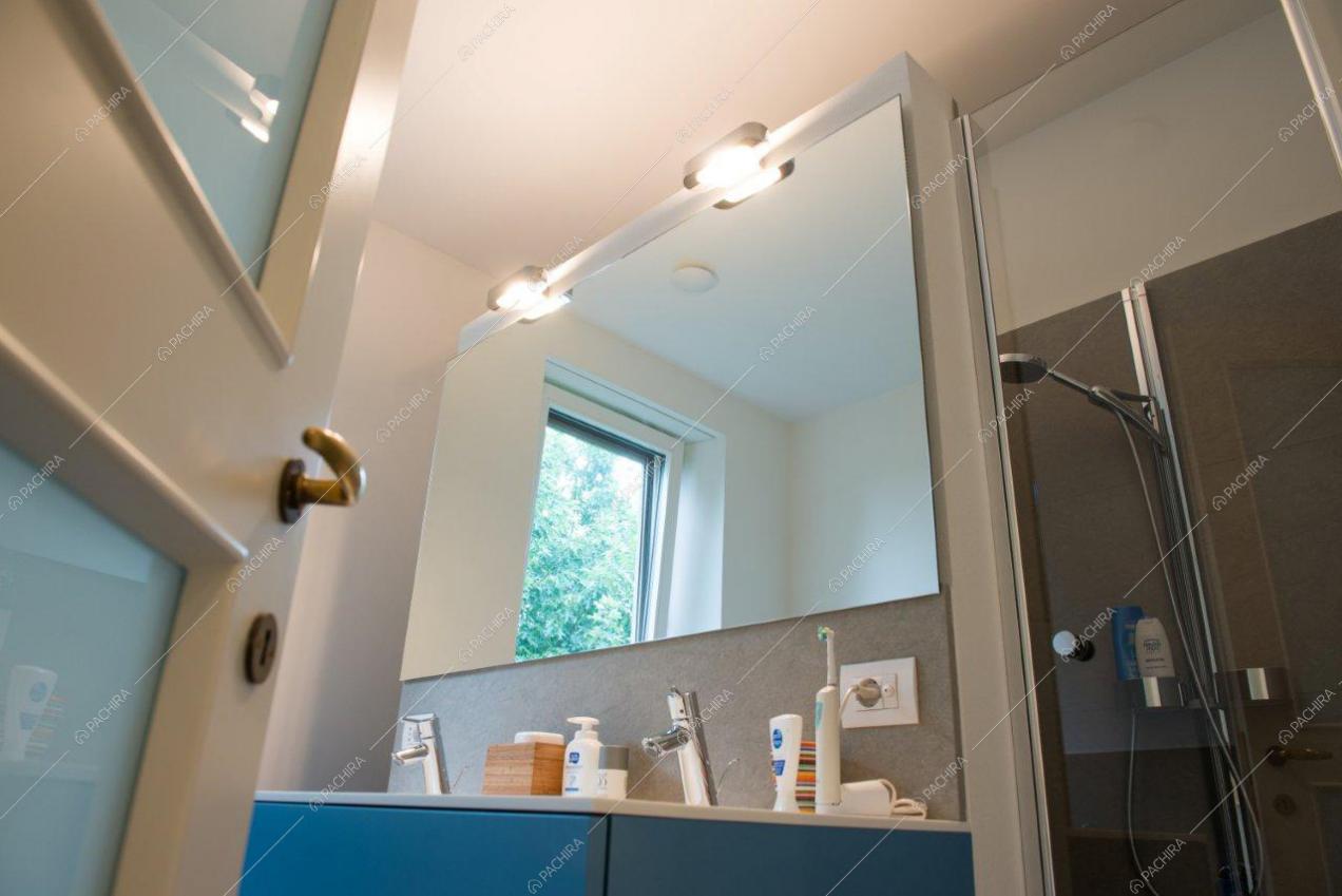 Bagno con mobile blu, doppio lavandino e doccia