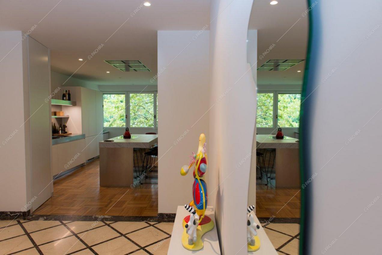 Dall'ingresso vista sulla cucina con isola illuminata da ampie vetrate