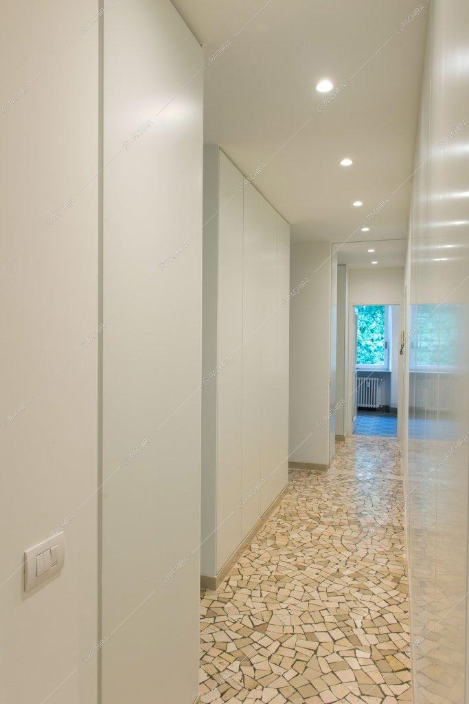 Corridoio banco con vista sul bagno e pavimento in marmo