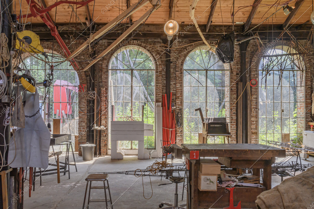Atelier luminoso con parete in mattoni a vista e finestroni