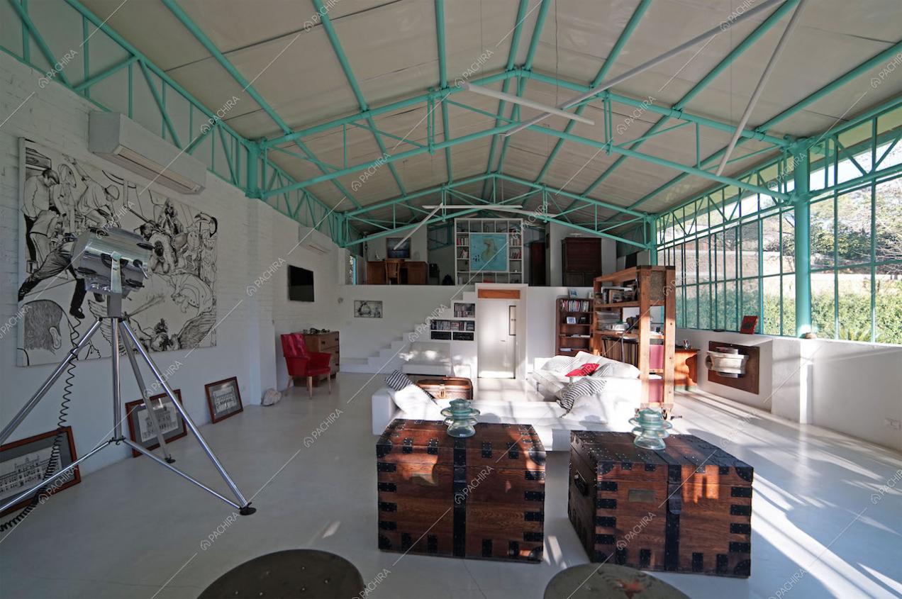 Zona living con divani bianchi, pavimento in cemento lisciato