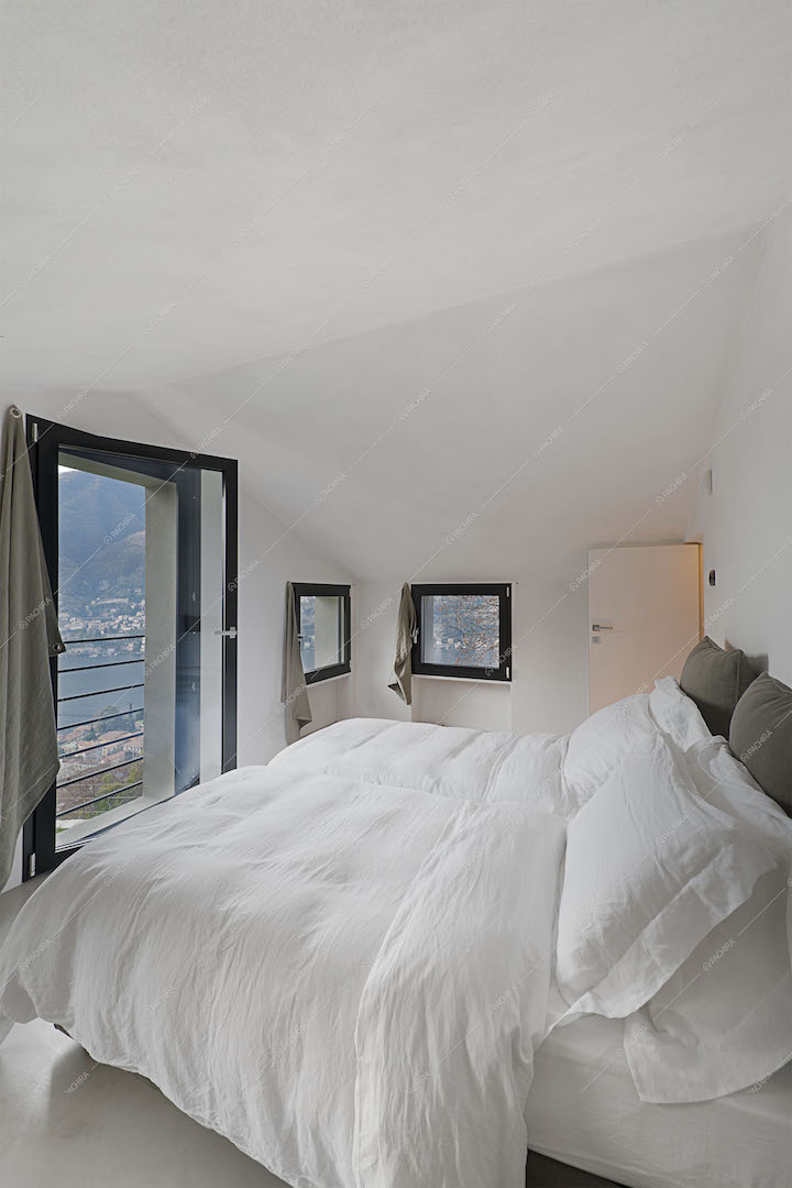 Camera da letto con vetrate vista lago