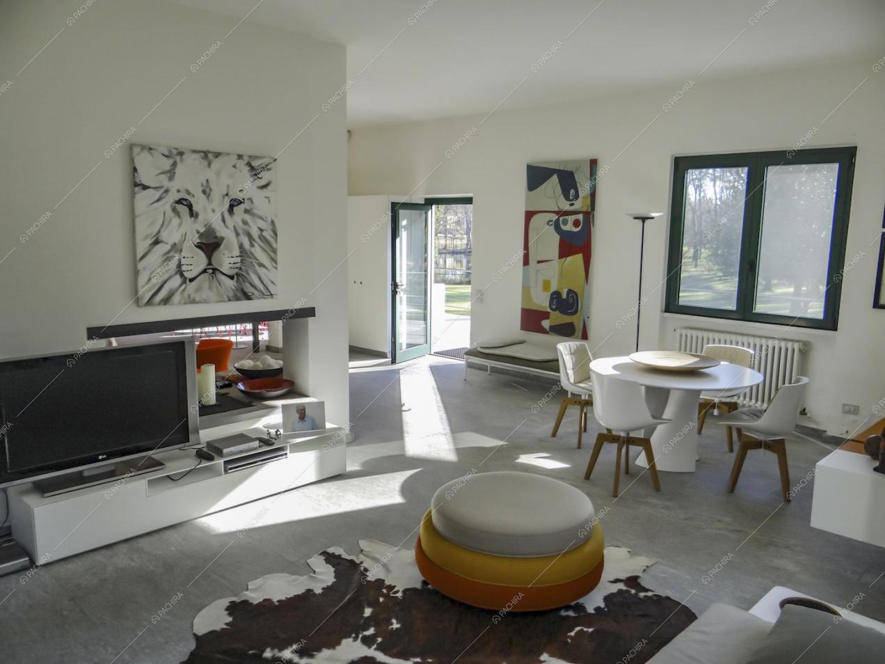 Sala dal pavimento in marmo con pouf di design e tavolo da pranzo bianco