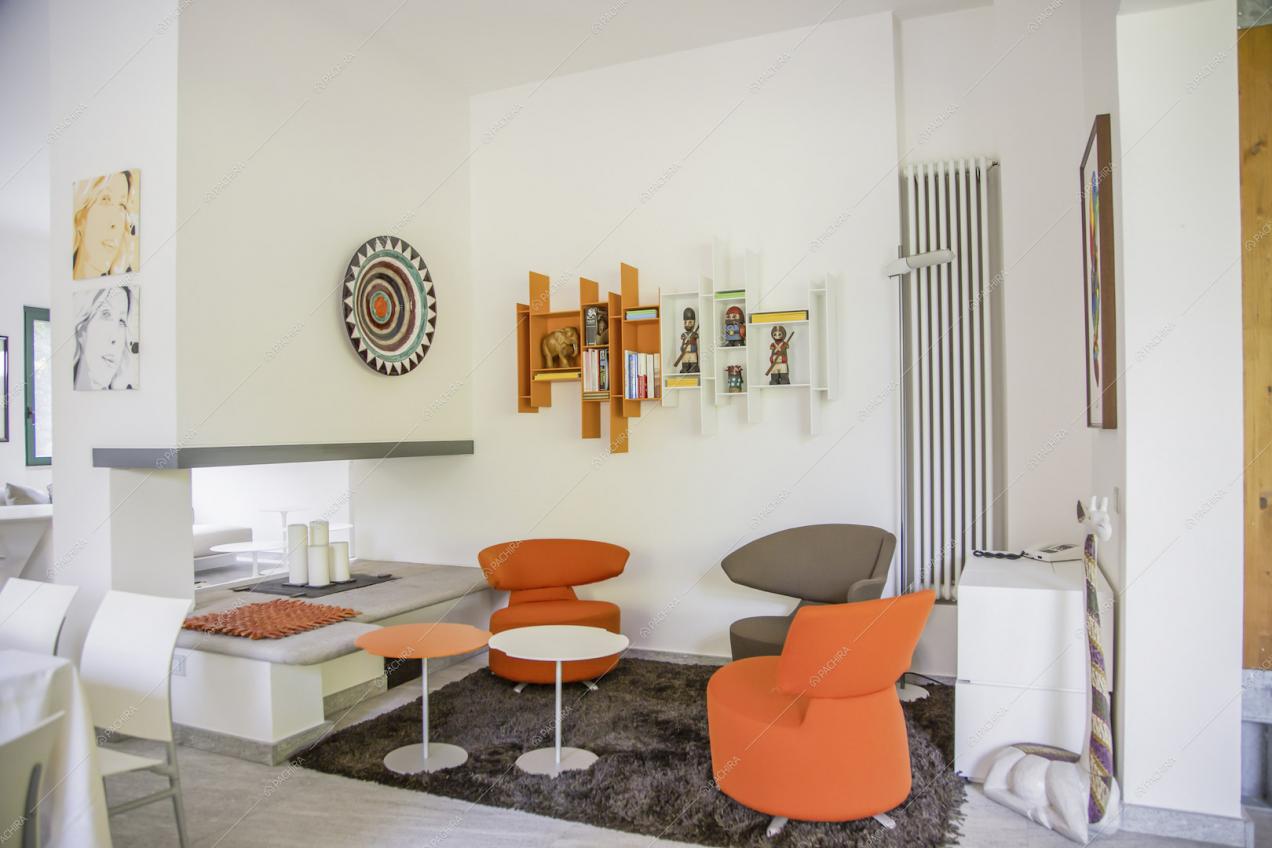 Salotto con poltrone di design, pareti bianche e pavimento in marmo