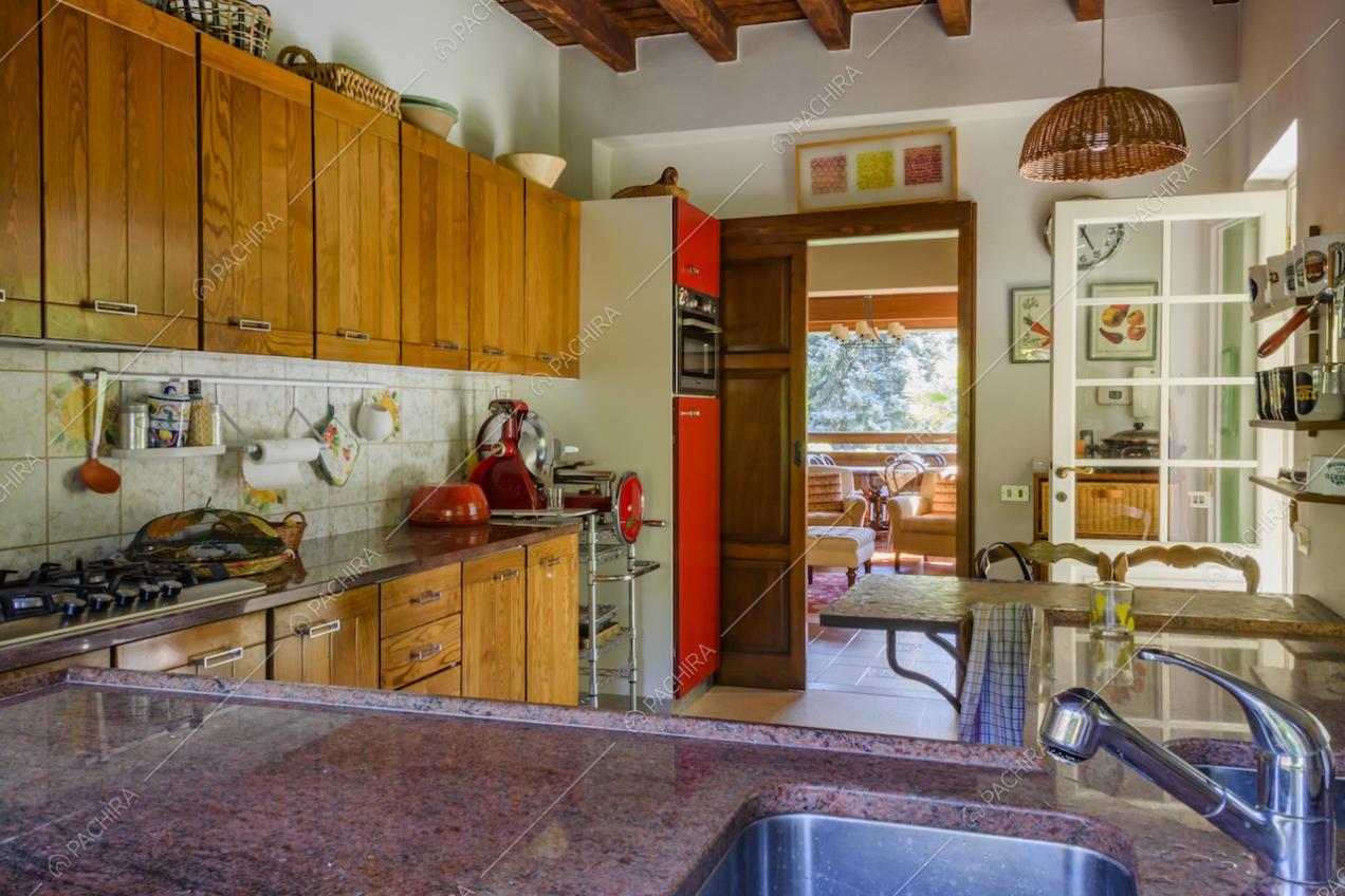 Travi a vista sul soffitto della cucina e affettatrice di design