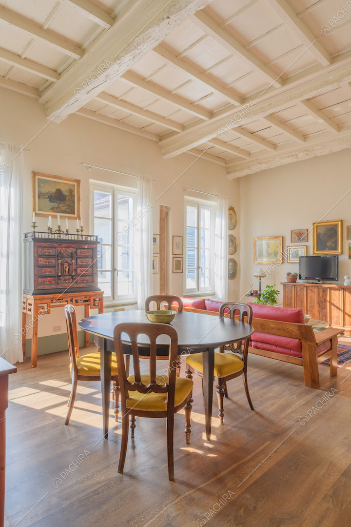 Tavolo da pranzo ovale, pavimento in parquet e soffitto a cassettoni bianco