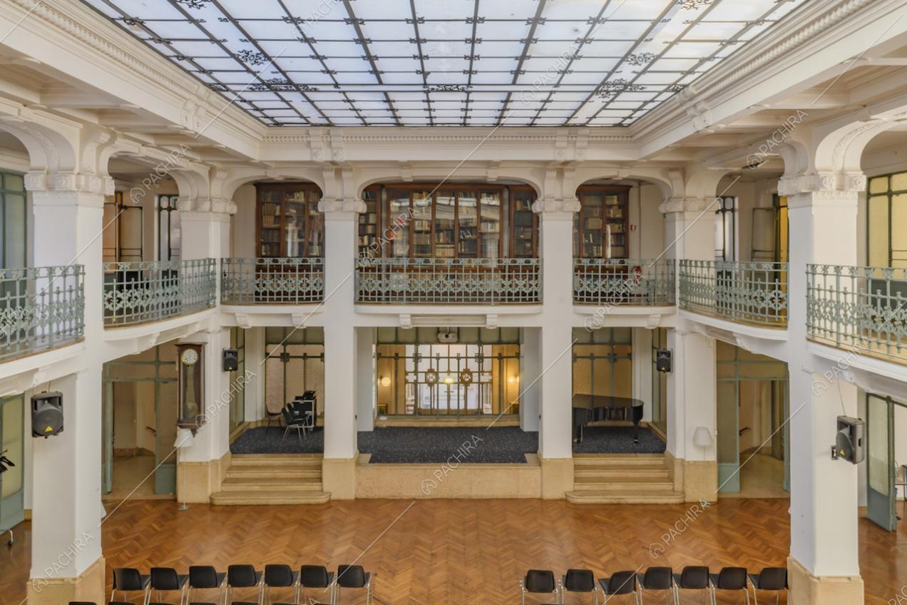 Vista dalla balconata sull'ampio salone con palco, pianoforte e pavimento in parquet