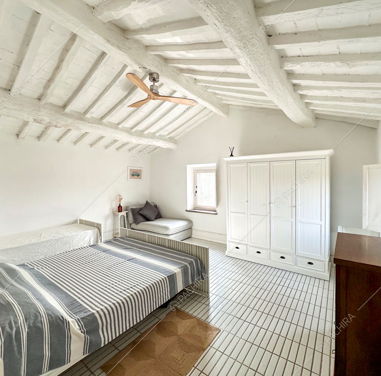 Luminosa camera da letto con pavimento in piastrelle bianche