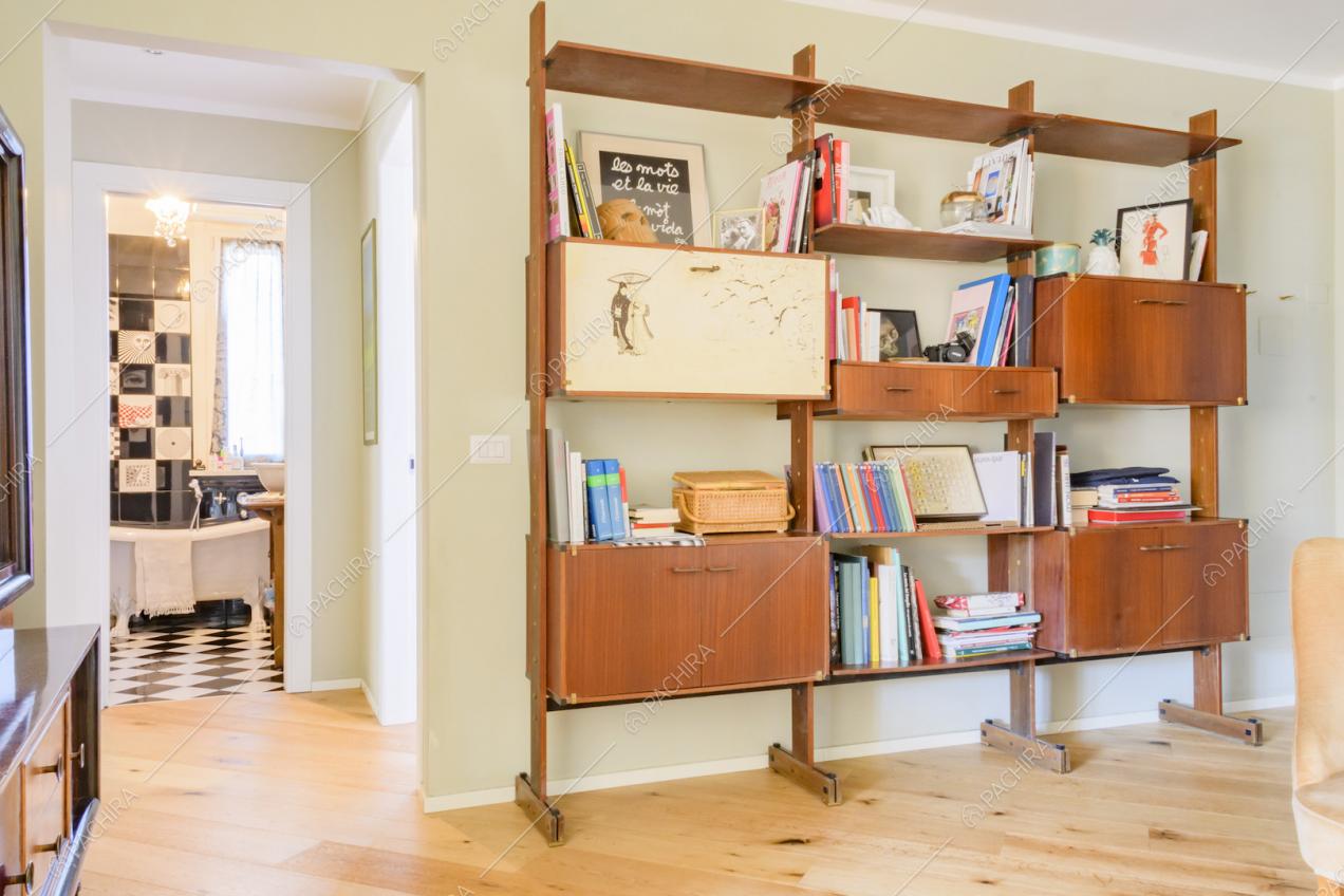 Libreria in legno con volumi e pavimento in parquet