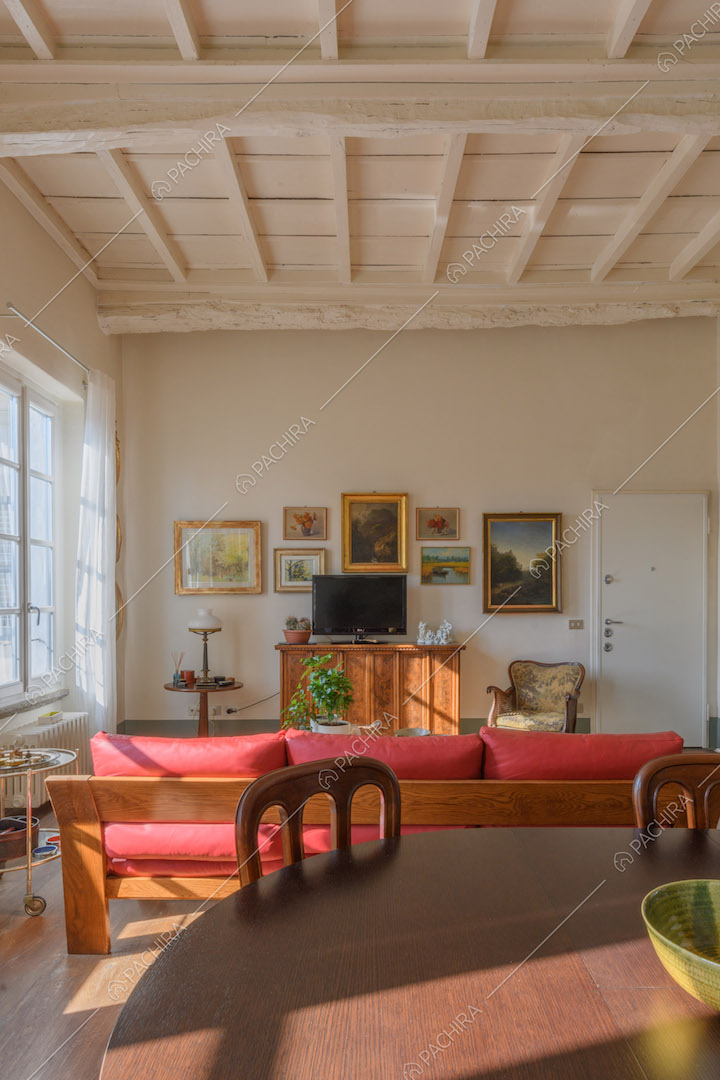 Luminosa sala con soffitto bianco a cassettoni, pavimento in parquet e tavolo da pranzo
