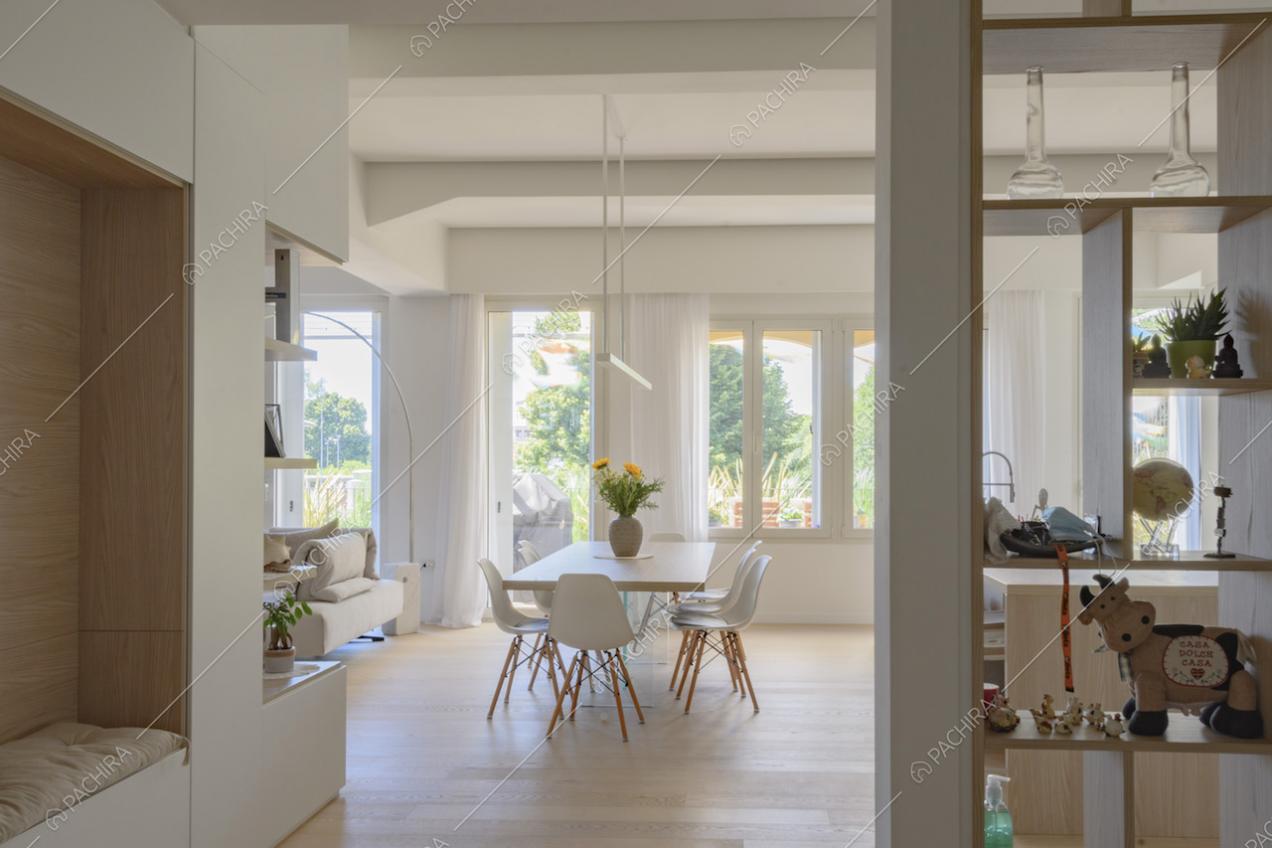 Scorcio sulla zona giorno con tavolo da pranzo e vetrate