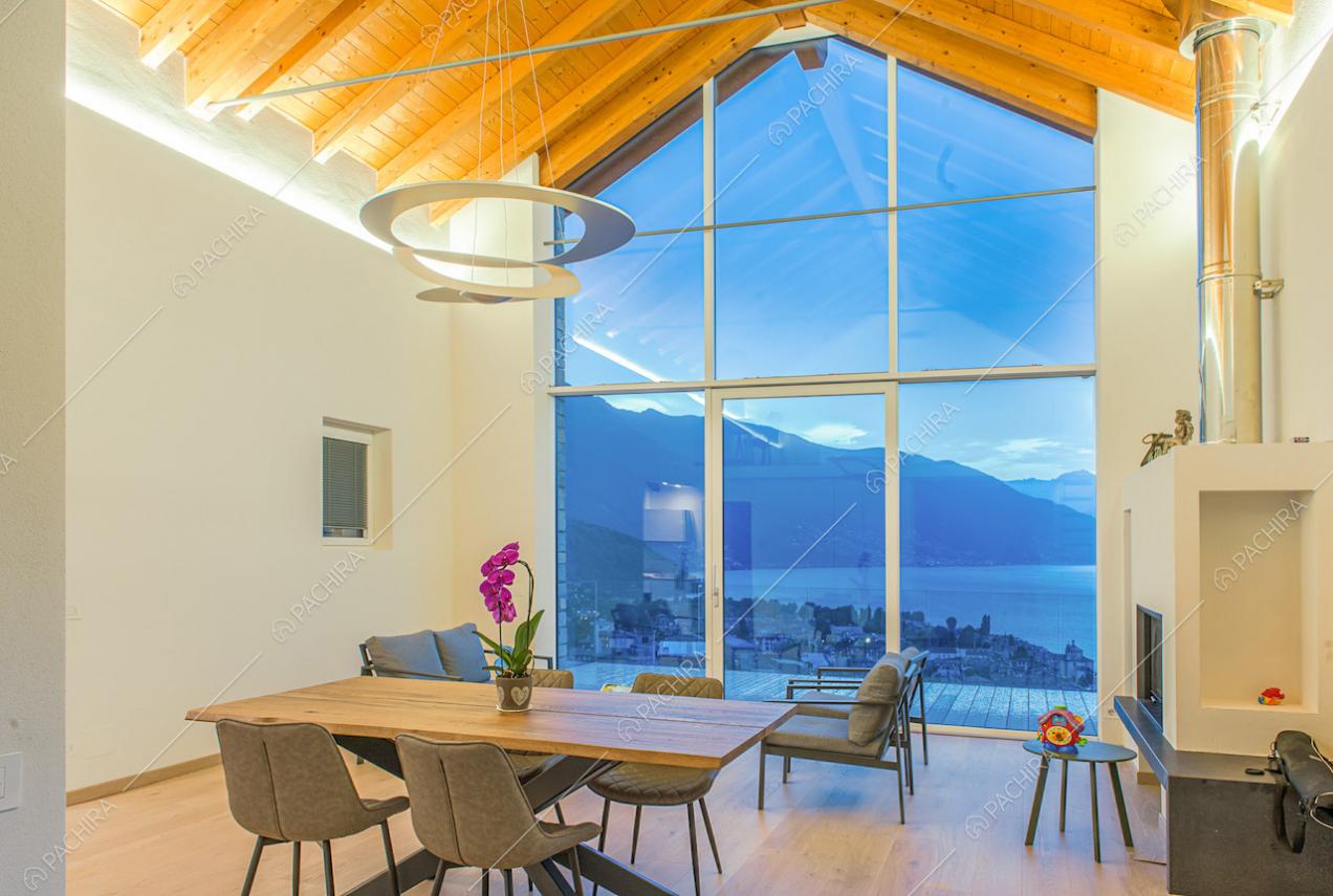 Soggiorno dalle pareti bianche, con soffitto in travi in legno a vista, camino e pavimento in parquet