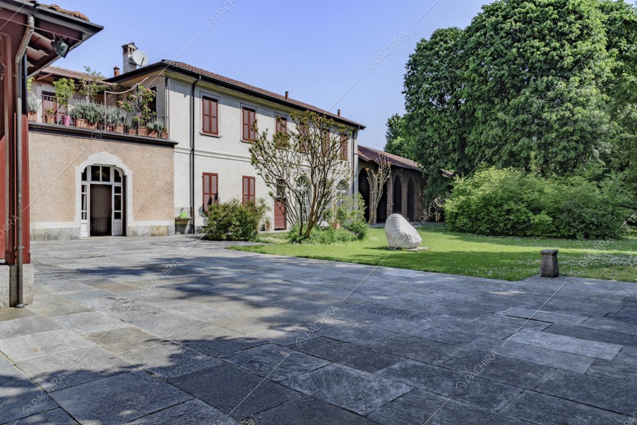 Esterni della dimora storica con vialetto in lastre di pietra e giardino privato