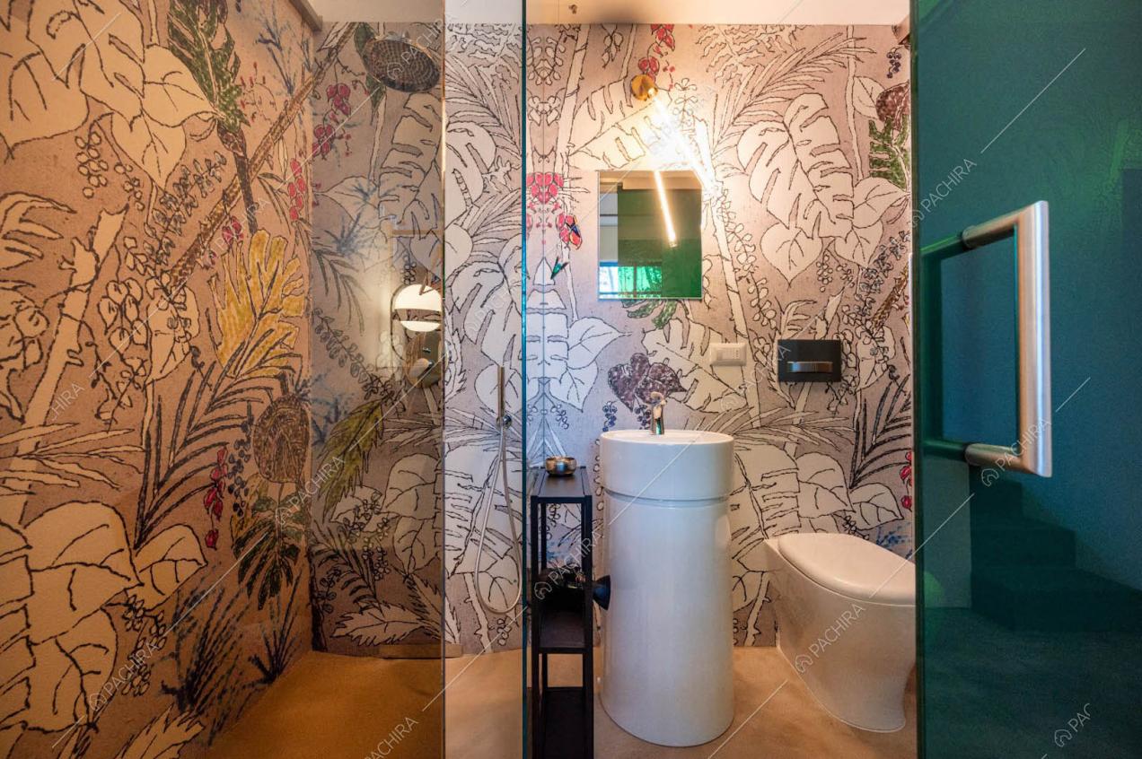 Carta da parati con fantasia tropicale nel bagno con pavimento in resina