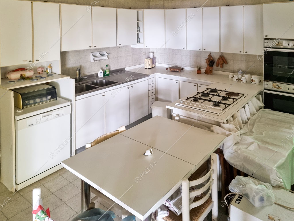 Cucina a parete con fornelli a gas e pavimento in piastrelle bianche