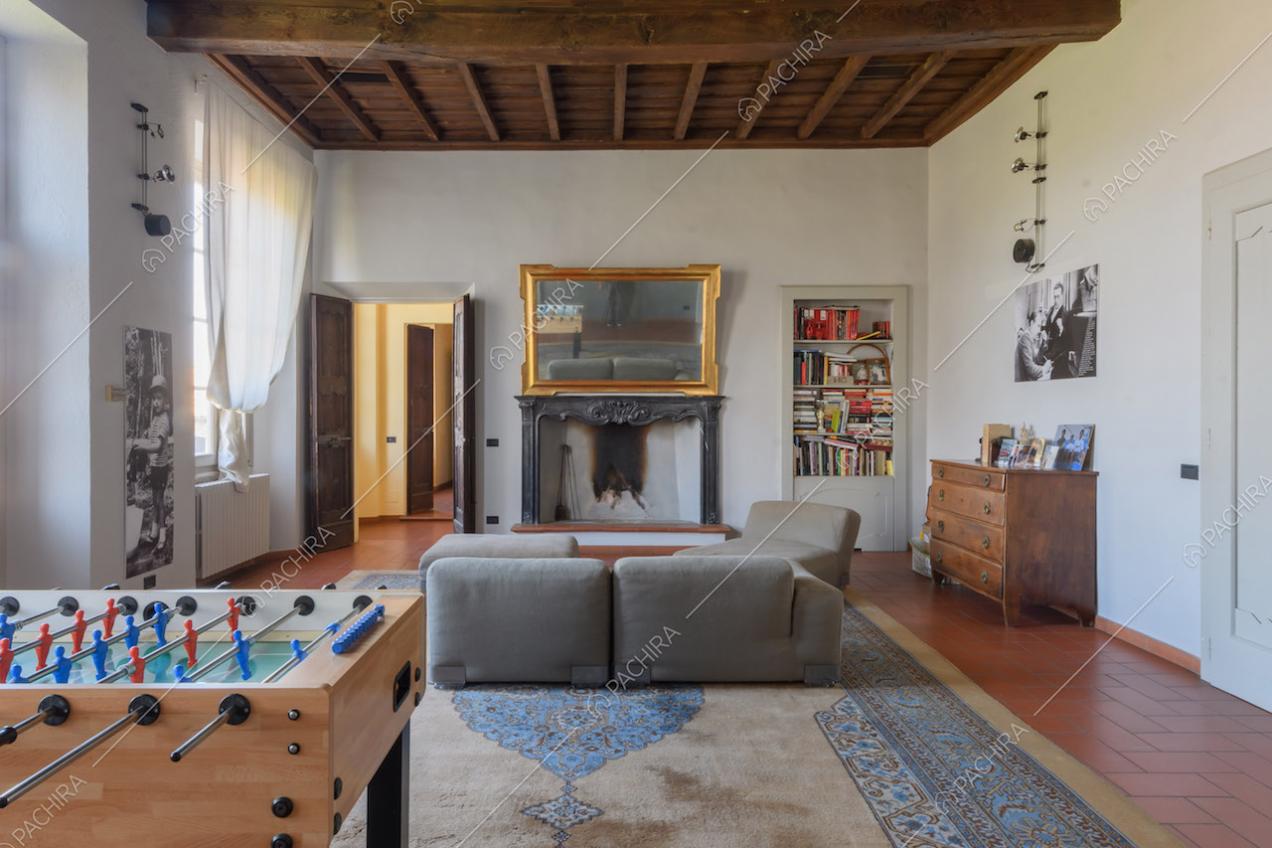 Luminoso salotto con pareti bianche, camino e soffitto a cassettoni