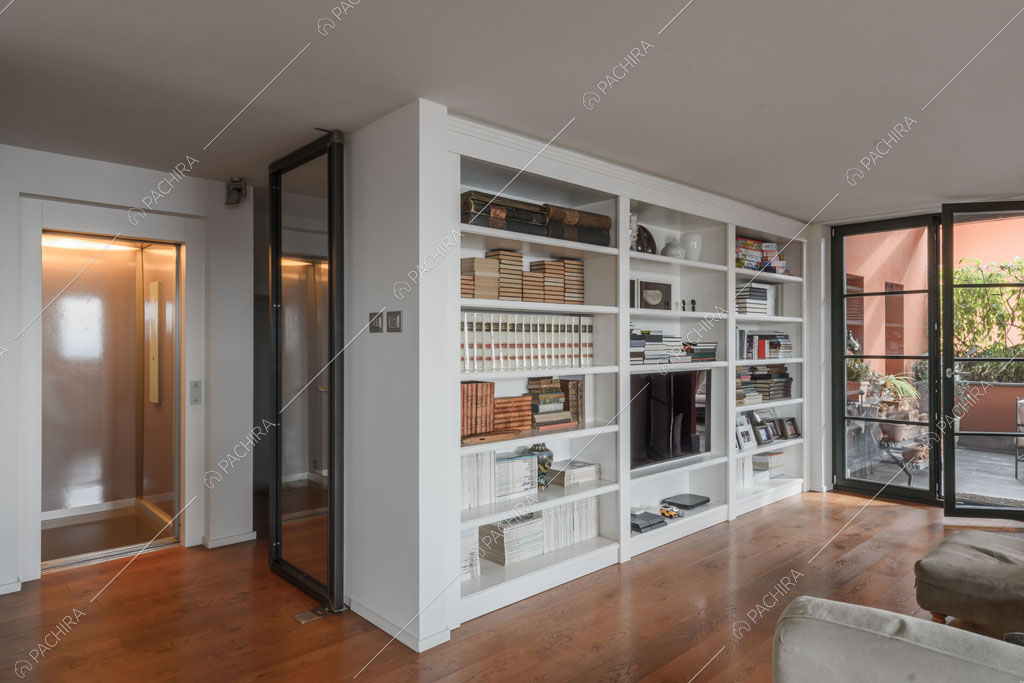 Sala con ascensore e libreria della villa Roveja, location in stile contemporaneo a Como