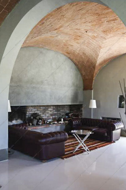 Soggiorno con divani in pelle e soffitto in mattoni
