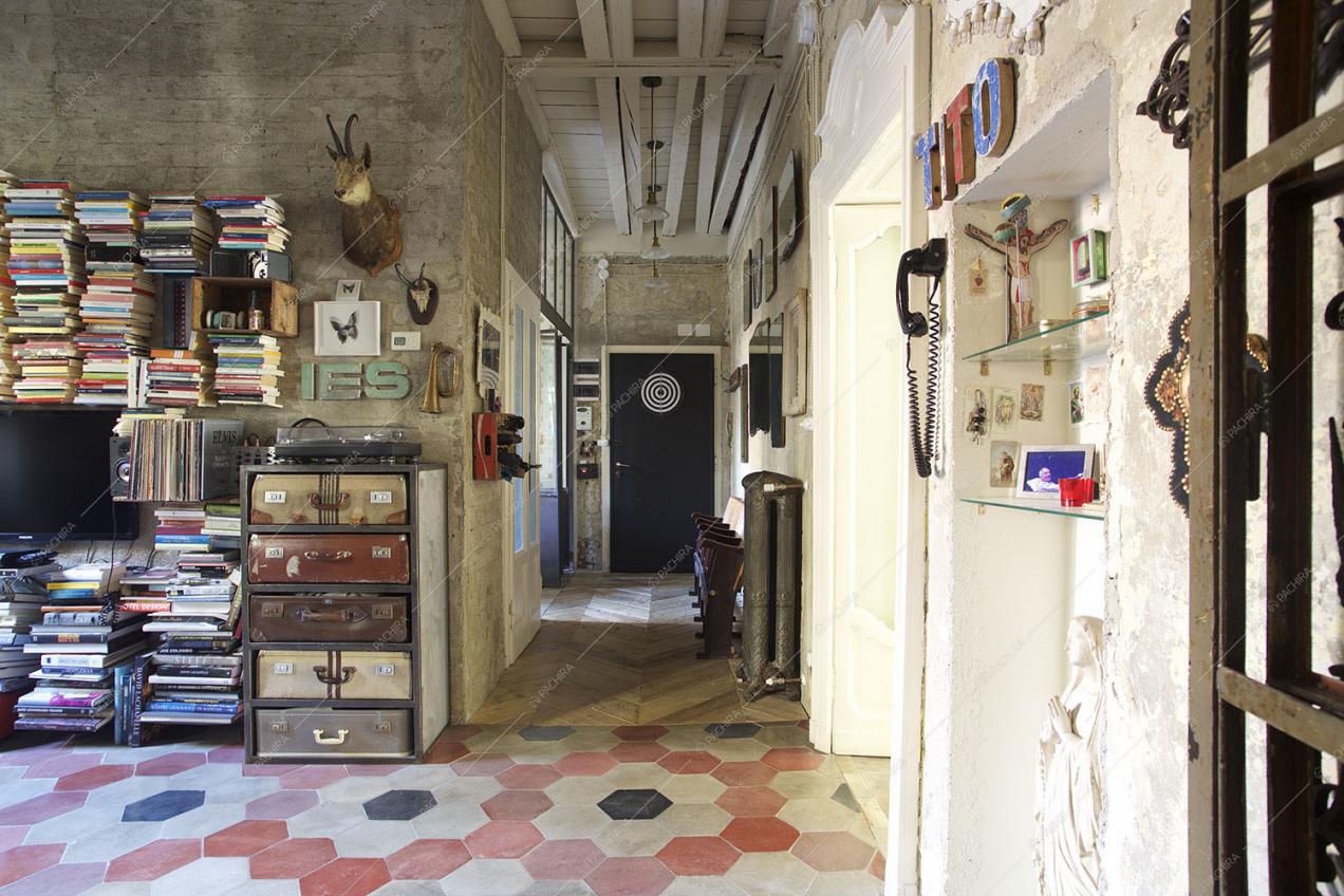 Soggiorno con pavimento in cementine, corridoio in parquet a spina di pesce