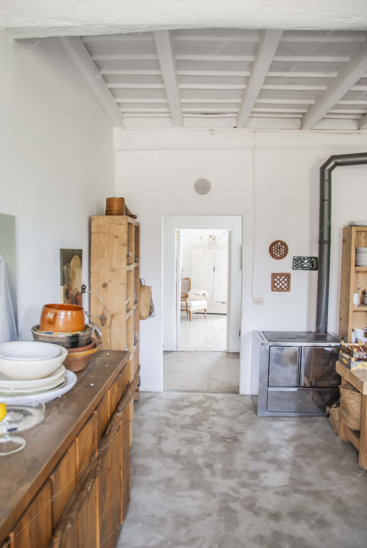 Travi a vista e pavimento in cemento lisciato in cucina