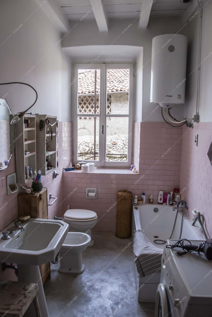 Bagno con pareti in piastrelle a mattoncini rosa