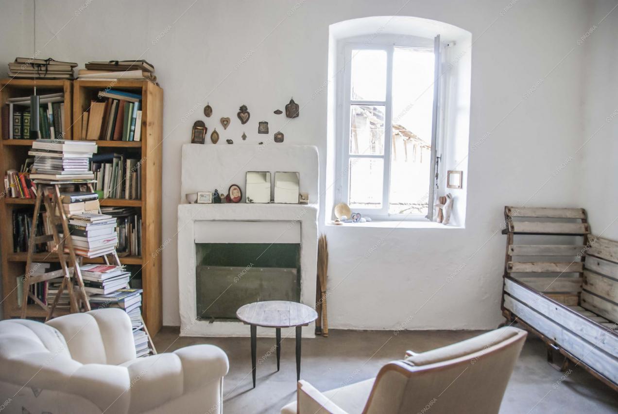Soggiorno con poltrone, camino, scala che funge da libreria