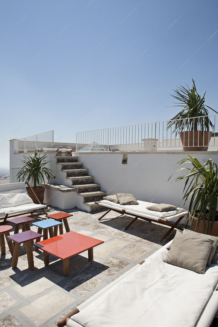 Terrazza con tavolini colorati, sdraio e divani