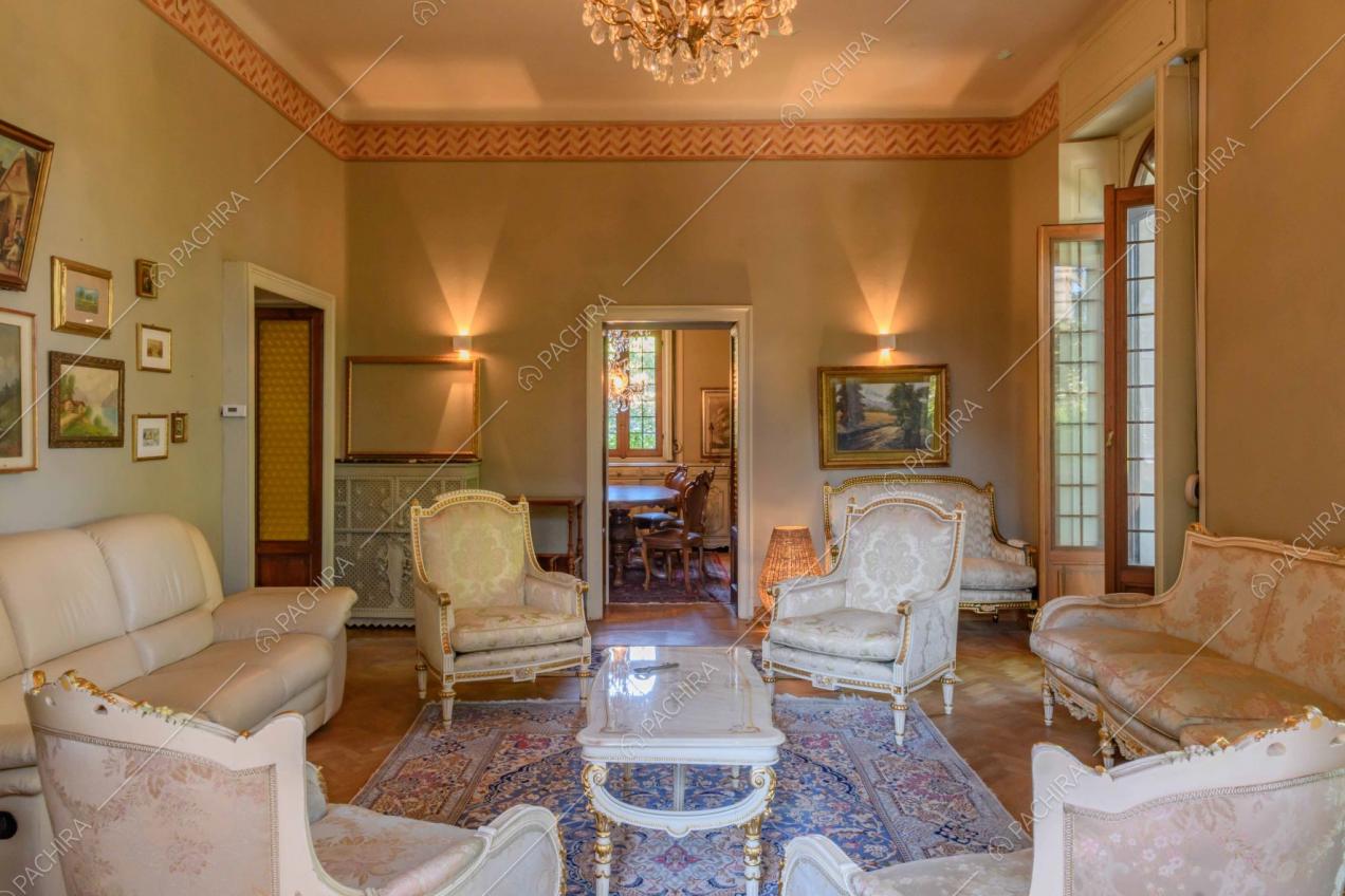 Dal salotto in stile classico vista sulla sala da pranzo con tavolo in legno