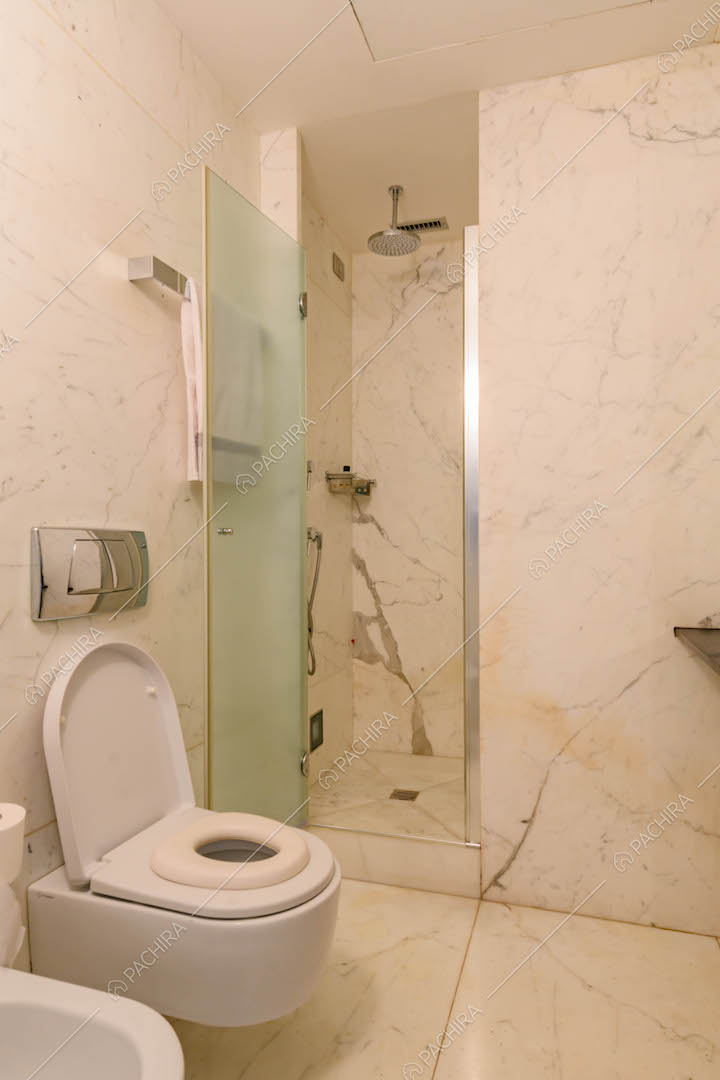 Bagno con box doccia, pavimento e pareti in marmo