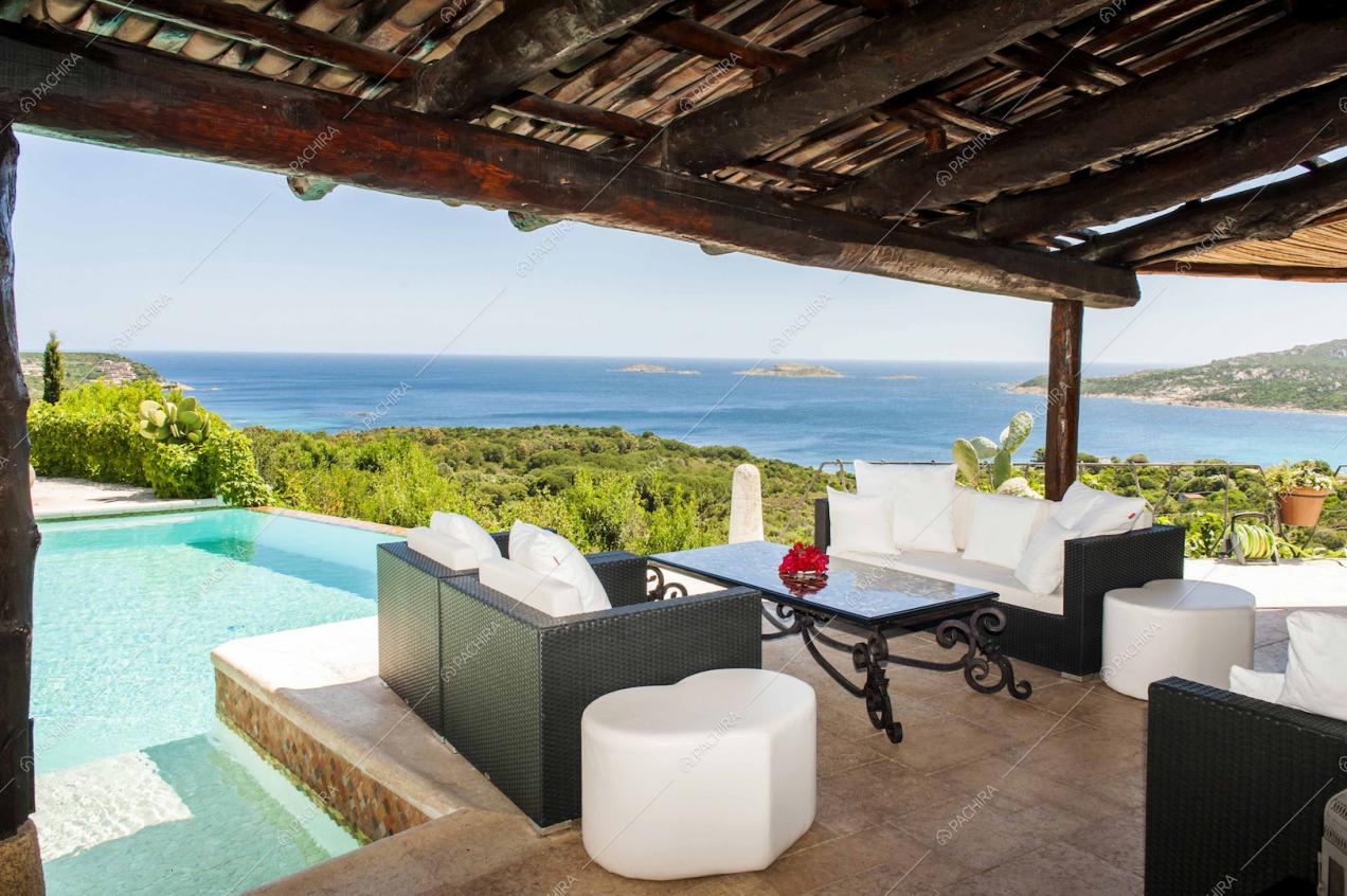 Terrazza con salottino di vimini e piscina con vista panoramica