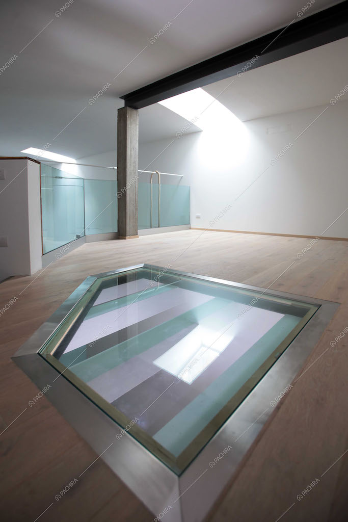 Stanza vuota con pavimento in parquet e vetrate
