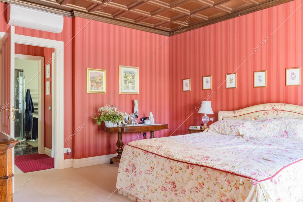 Soffitto a cassettoni e carta da parati rossa nella camera da letto